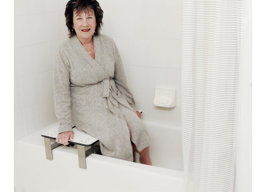 Woman sitting on bathtub transfer bench