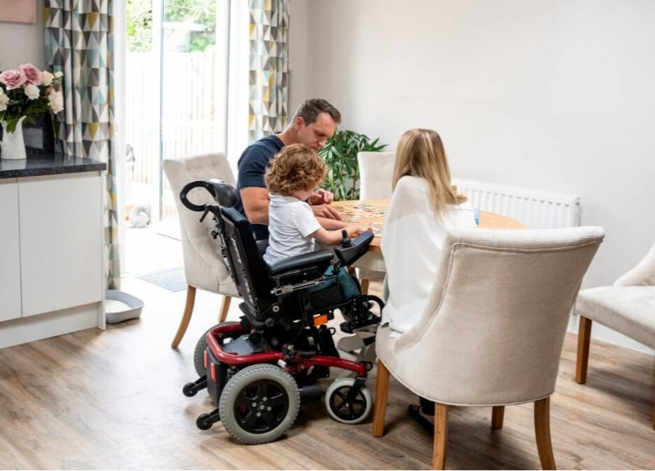 Freedom Showers and accessible bathrooms for state medicaid waiver programs family with child in wheelchair at the table
